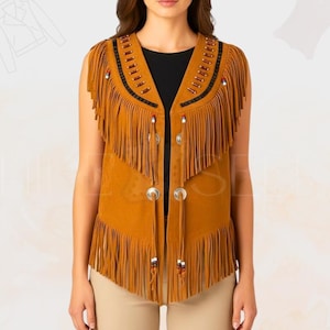 Peut inclure: Un gilet en daim marron clair avec de longues franges. Le gilet présente des boutons argentés et des perles décoratives le long de l'encolure et des bords des franges. Le gilet est sans manches et a un col en V.