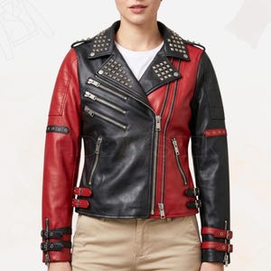 May include: A two-tone black and red leather jacket with silver stud accents on the shoulders and collar. The jacket features multiple zippered pockets, a diagonal zipper closure, and buckle details on the sleeves and waist.