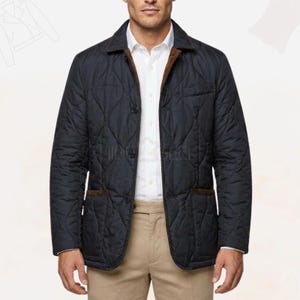 Può includere: Giacca trapuntata blu navy con colletto e rifiniture delle tasche in velluto a coste marrone. La giacca ha una chiusura con bottoni e due tasche anteriori. Il modello indossa una camicia bianca e pantaloni beige. Capo di abbigliamento classico.