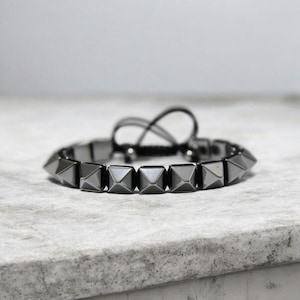 Bracciale a piramide in ematite: gioiello regolabile in macramè color argento