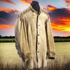 Könnte beinhalten: Eine braune Lederjacke mit Fransen an Schultern, Ärmelbündchen und Vorderseite. Die Jacke hat einen Knopfverschluss und ist vor einem Sonnenuntergangshintergrund fotografiert.