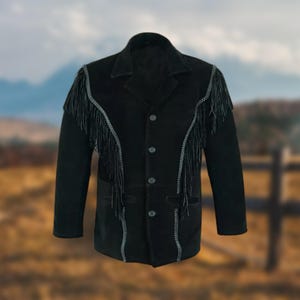 Puede incluir: Una chaqueta de gamuza negra con detalles de flecos a lo largo de las costuras y los bolsillos. La chaqueta tiene un cierre frontal con botones y mangas largas.