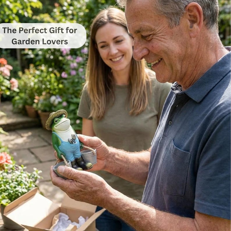 May include: A ceramic frog figurine wearing a straw hat, blue overalls, and black boots, holding a small bucket and gardening tools. The figurine is green and white with brown accents. The text "The Perfect Gift for Garden Lovers" is in a white oval.