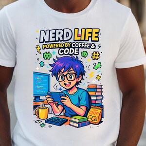 Può includere: Maglietta bianca con un'illustrazione di un cartone animato di una persona che codifica. Il testo sulla maglietta recita "Nerd Life Powered by Coffee & Code".