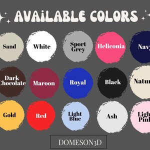 May include: A graphic displaying a variety of available colors for a product. The colors are displayed in circular shapes and include Sand, White, Sport Grey, Heliconia, Navy, Dark Chocolate, Maroon, Royal, Black, Natural, Gold, Red, Light Blue, Ash, and Light Pink.