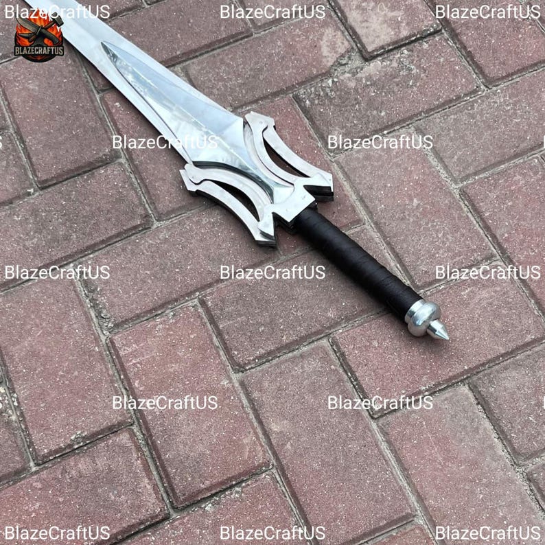 May include: A silver-colored sword with a decorative hilt and a black handle. The sword is lying on a brick surface. The text "BlazeCraftUS" is repeated across the image.