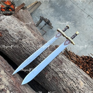 May include: Two decorative swords with light blue blades and gold-colored crossguards. The handles are black and gold. The swords are lying on a wooden surface. The text "BlazecraftUS" is visible on the image.