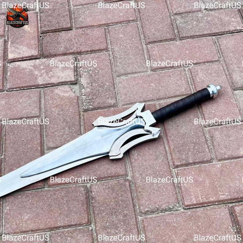May include: A silver and black sword with a wide, polished blade. The hilt is black with a silver guard. The sword is lying on a brick surface. The sword has a decorative design on the guard.