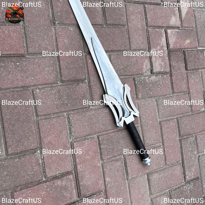 May include: A silver-colored sword with a stylized hilt and a black wrapped handle. The blade is long and straight, with a pointed tip. The sword is set against a brick background. The logo "BlazeCraftUS" is visible in the image.