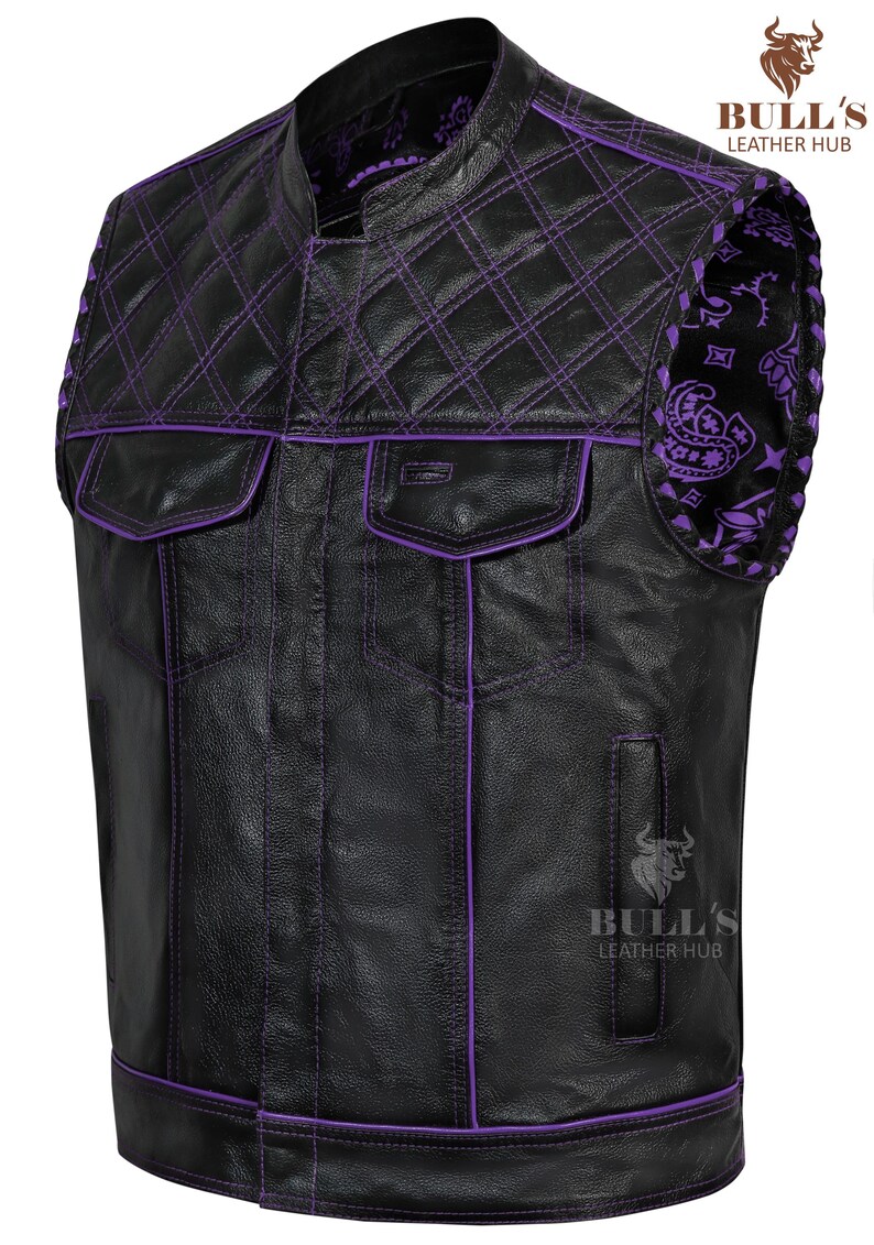 May include: Black leather vest with purple stitching and accents. Features a quilted shoulder design and two front pockets. The vest has a stand-up collar and a paisley pattern on the shoulder. The Bull's Leather Hub logo is visible.