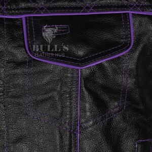 May include: Close-up of a black leather jacket with purple stitching and trim. The jacket features a pocket with the text "BULL'S LEATHER HUB" and a bull logo. The stitching creates a diamond pattern on the upper back.