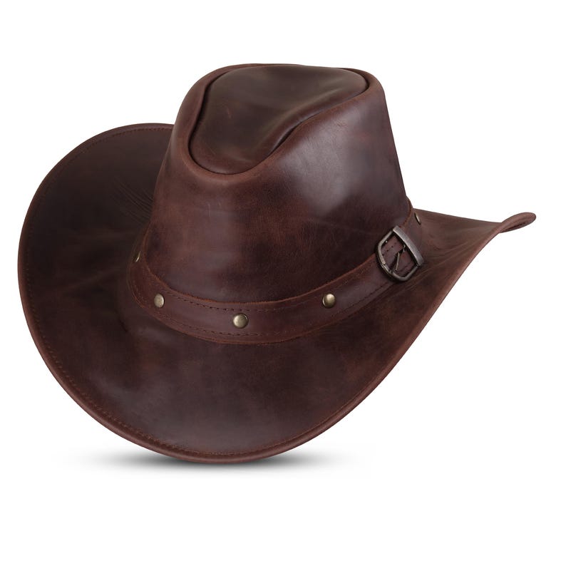 May include: A brown leather cowboy hat with a wide brim and a buckle on the band.