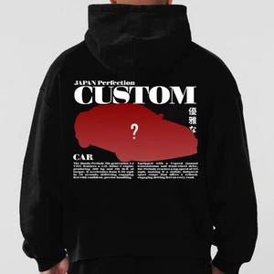 Könnte beinhalten: Schwarzer Kapuzenpullover mit roter Autografik und dem Wort "CUSTOM" in Weiß. Der Text "JAPAN Perfection" befindet sich über der Autografik. Zusätzlicher Text enthält "CAR" und eine Beschreibung des Honda Prelude.