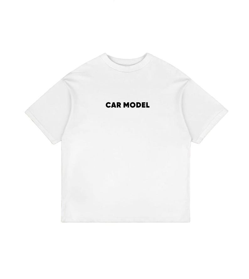 May include: A white t-shirt with the text "CAR MODEL" printed in black across the chest. The shirt has short sleeves and a crew neck. The fabric appears to be a soft, lightweight material.