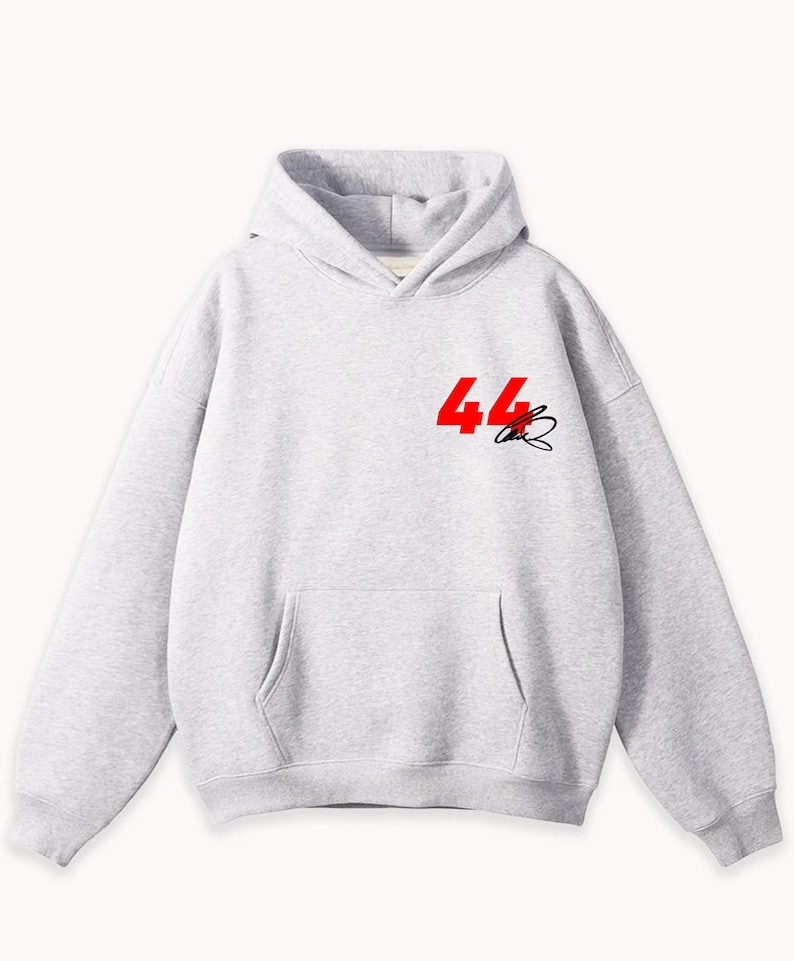 May include: A light gray hoodie with a front pocket and hood. The number "44" in red and a black signature are printed on the upper left chest area. The hoodie is made of a soft material.