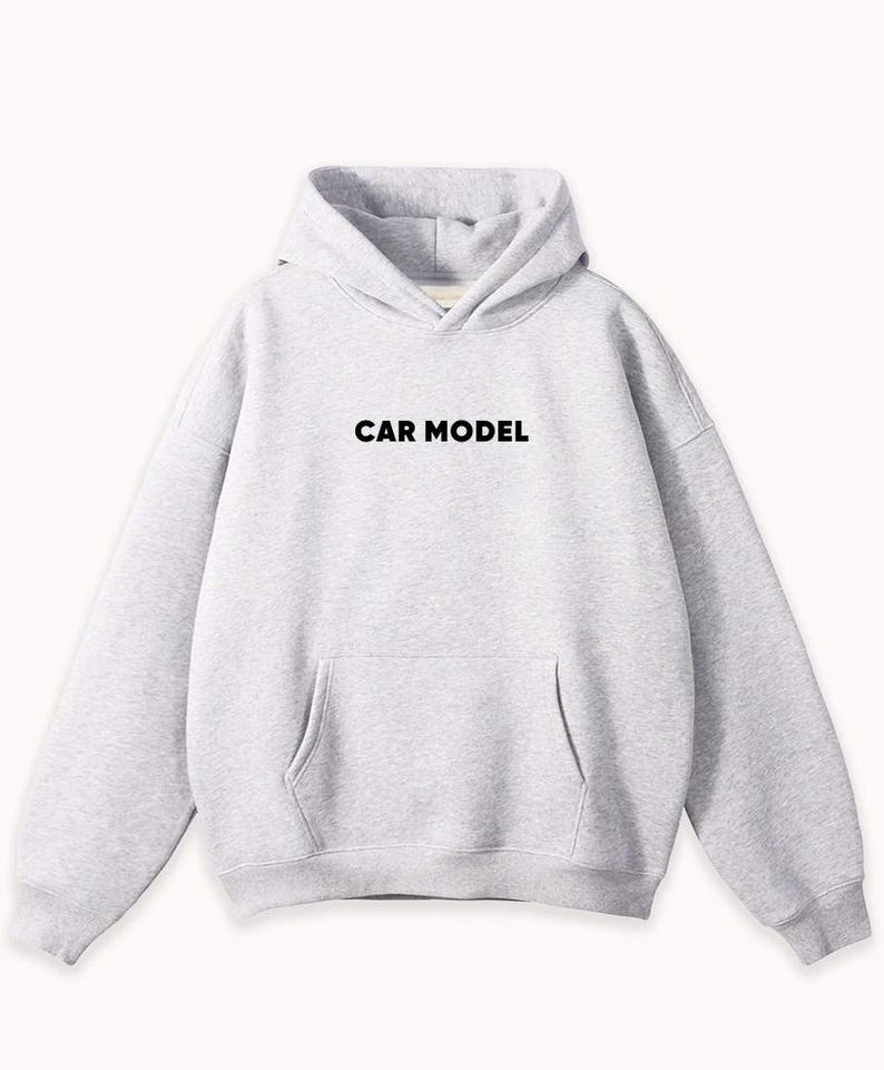 May include: A light gray hoodie with a front pocket and a hood. The text "CAR MODEL" is printed in black across the chest. The sweatshirt is made of a soft material.