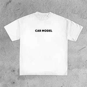 May include: White t-shirt with the text "CAR MODEL" printed in black across the chest. The shirt has a crew neck and short sleeves. The fabric appears to be a soft, medium-weight material.