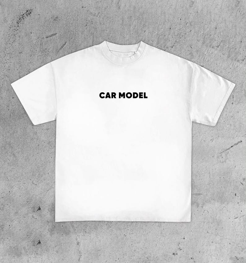 May include: White t-shirt with the text "CAR MODEL" printed in black across the chest. The shirt has a crew neck and short sleeves. The fabric appears to be a soft, medium-weight material.