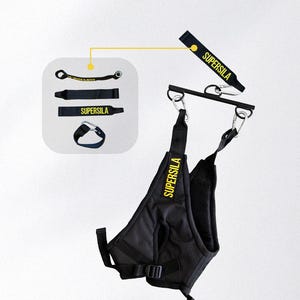 May include: Black weightlifting harness with the text "SUPERSILA" in yellow. The harness has a padded design and adjustable straps. Additional weightlifting accessories are also shown, including straps and a wrist support, all with the "SUPERSILA" logo.