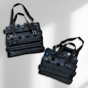 Puede incluir: Dos bolsos tote negros con correas ajustables y herrajes metálicos plateados. Cada bolso tiene un logotipo azul en la parte delantera. Los bolsos están diseñados con múltiples correas horizontales y asas verticales.
