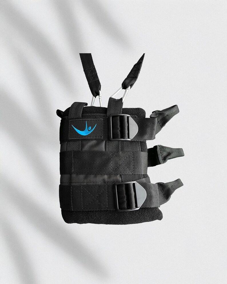 May include: Black weight vest with adjustable straps and buckles. Features a blue logo on the front. The vest has multiple straps and is designed for fitness training.