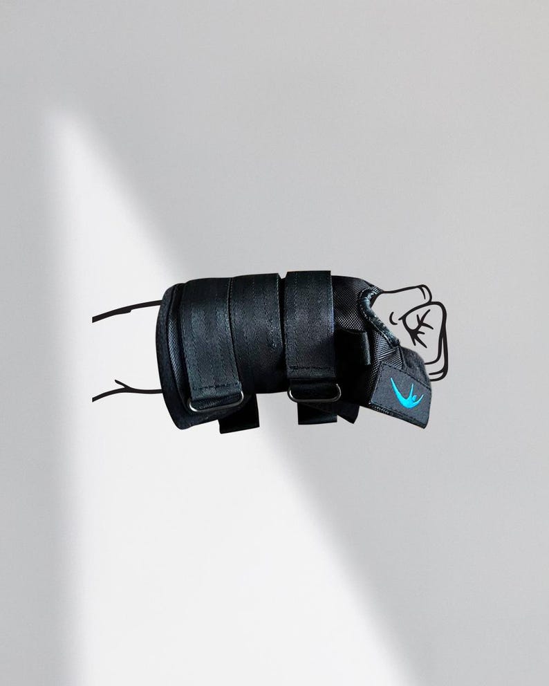 May include: Black wrist brace with adjustable straps and a blue logo. The brace is designed to support the wrist and hand. The image shows the brace in a fist position, suggesting its use in sports or injury recovery.