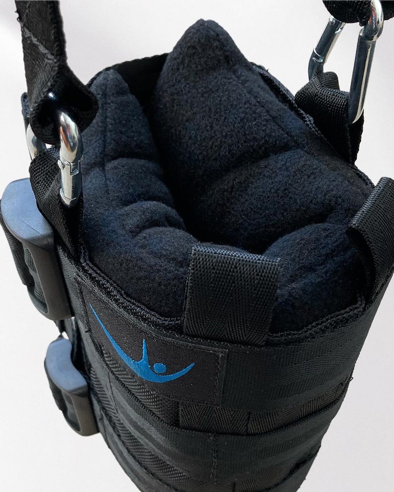 May include: Black inversion boots with a padded interior and adjustable straps. The boots have a blue logo and are designed to hang from a bar for inversion therapy. The boots are made of durable materials and feature metal carabiner clips.