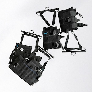 May include: Black inversion therapy equipment with multiple straps, buckles, and metal bars. The equipment has a blue logo and is designed for hanging upside down. The image shows several pieces of the equipment, likely for different body parts.