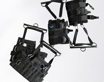 May include: Black inversion therapy equipment with multiple straps, buckles, and metal bars. The equipment has a blue logo and is designed for hanging upside down. The image shows several pieces of the equipment, likely for different body parts.