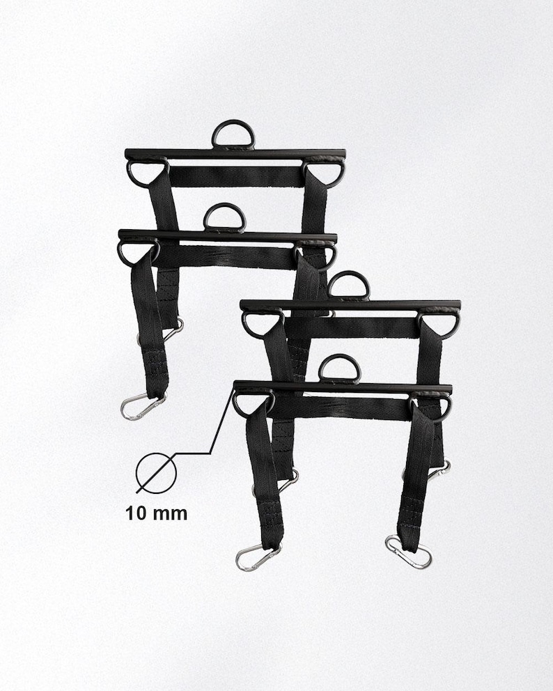 May include: Two black weightlifting attachments with D-rings and carabiner clips. Each attachment has a 10 mm diameter. The attachments are designed for use with weightlifting equipment.