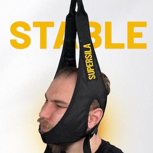 May include: Black neck traction device with the word "SUPERSILA" in yellow. The device is suspended from a metal hook. The word "STABLE" is in large yellow letters in the background.