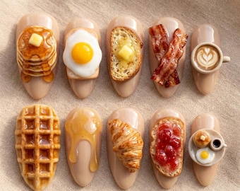 May include: A set of ten artificial nails with breakfast-themed designs. Each nail features a different miniature food item, including pancakes, eggs, toast, bacon, coffee, a waffle, honey, a croissant, toast with jam, and a plate with mini pancakes and eggs.