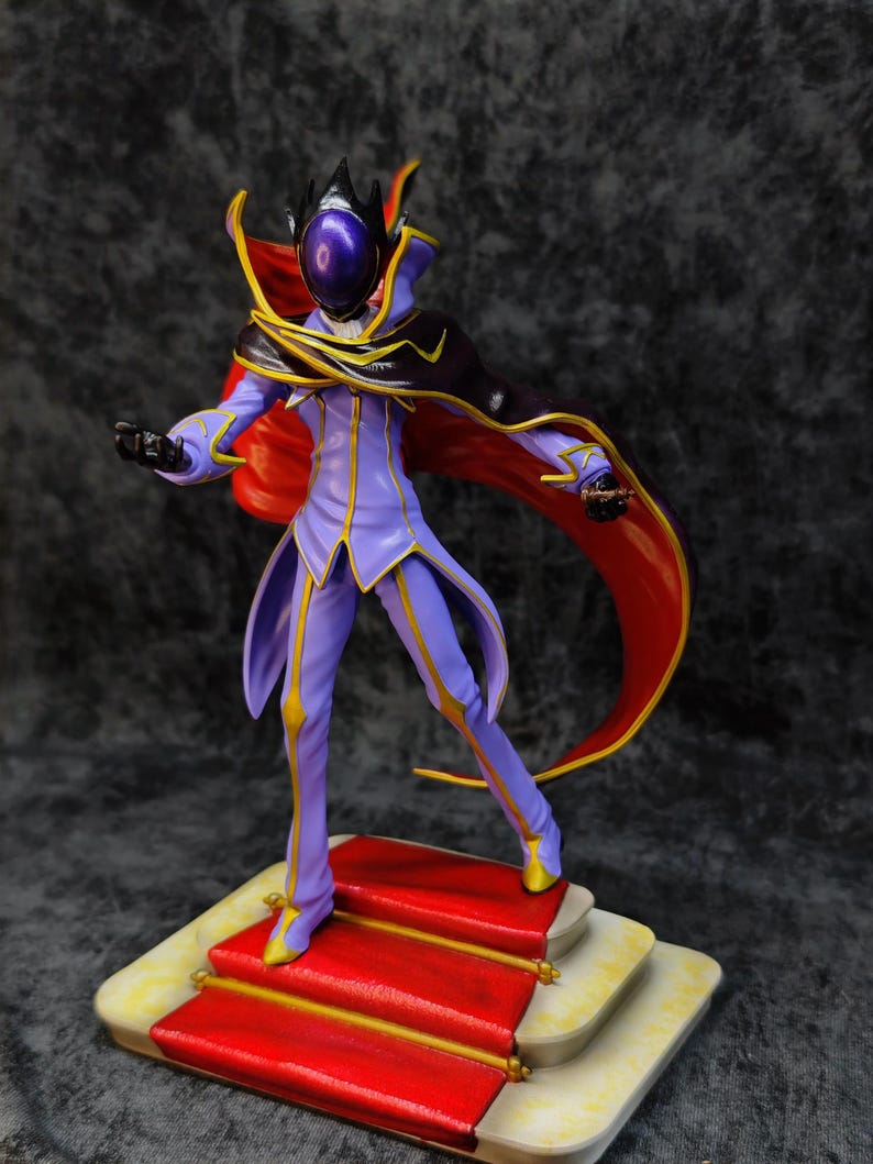 Pu&ograve; includere: Statuetta dettagliata di un personaggio in un completo viola e oro con un mantello rosso. La figura &egrave; su una base a pi&ugrave; livelli con un tappeto rosso. Il personaggio ha un elmo con una visiera viola.