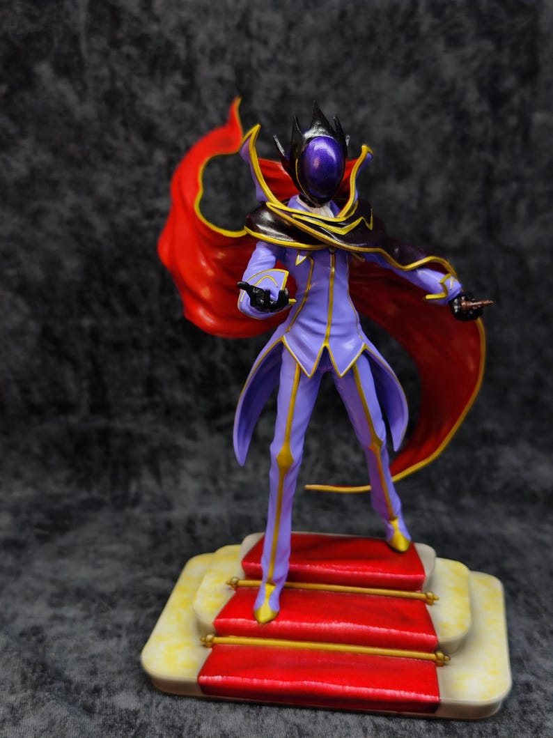 Pu&ograve; includere: Statuetta dettagliata di un personaggio in un completo viola e oro con un mantello rosso. La figura &egrave; su una piattaforma con moquette rossa e finiture dorate. Il personaggio ha un elmo con visiera viola e corona nera.