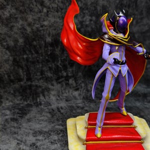 Pu&ograve; includere: Una statuetta di un personaggio in un completo viola e oro con un mantello rosso. La figura &egrave; in piedi su una piccola piattaforma con dettagli rossi e gialli. Il personaggio ha un elmo con una visiera viola.