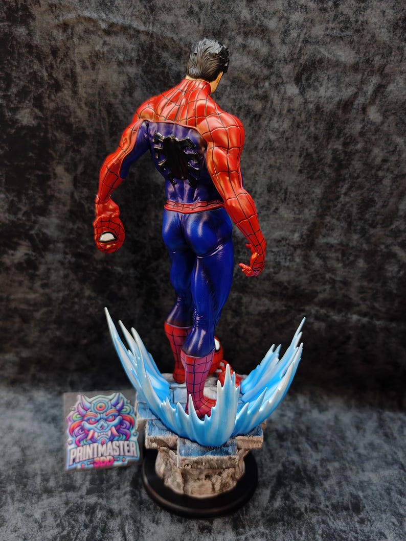 Op de afbeelding: Een gedetailleerd beeld van Spider-Man, van achteren gezien, met zijn iconische rood-blauwe pak. De figuur is dynamisch geposeerd en staat op een basis met waterachtige effecten. Het beeld heeft een gedetailleerd gespierd lichaam en is een verzamelobject.