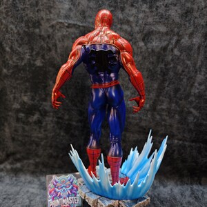 Op de afbeelding: Een gedetailleerd beeldje van Spider-Man, van achteren gezien, met zijn iconische rood-blauwe pak. De figuur staat op een voetstuk met een watereffect, met een logo zichtbaar op de voet. De figuur is ongeveer 30 cm hoog.