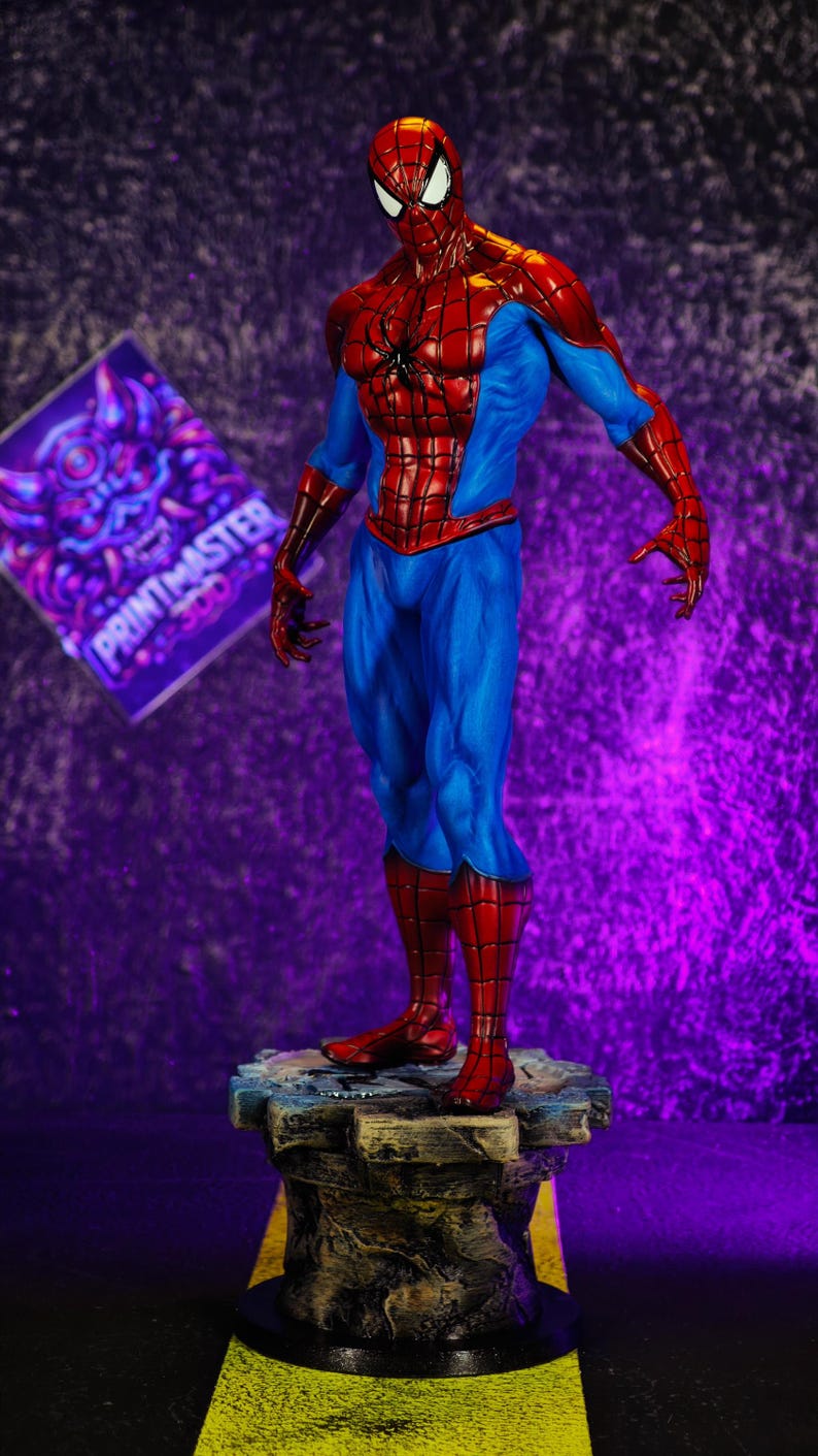 Puede incluir: Una detallada figura de Spider-Man con su cl&aacute;sico traje rojo y azul, de pie sobre una base rocosa. La figura tiene una pose din&aacute;mica, mostrando el dise&ntilde;o ic&oacute;nico del personaje. El fondo es un degradado de morado y negro.