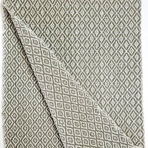 May include: A folded green and white diamond patterned throw blanket with a fringed edge.