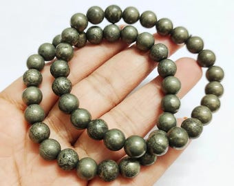 May include: Two pyrite beaded bracelets. The beads are a metallic grey colour with a slightly textured surface. The bracelets are displayed on a white background.