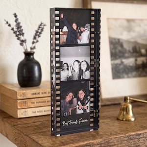 May include: A rectangular acrylic photo block designed to resemble a strip of 35mm film. The clear block features three vertical black and white photographs of people and the text "Best Friends Forever" printed at the bottom.