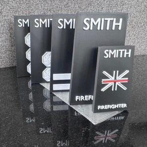 May include: Black and white name plaques with the name "SMITH" and the words "FIREFIGHTER" and a red and white cross.