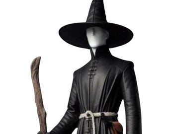 May include: A black figure wearing a wide-brimmed hat and long coat, holding a wooden staff. The figure has a blank, white face and a rope belt. A small brown pouch hangs from the belt. The outfit is reminiscent of a wizard or sorcerer.