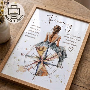 May include: A framed print featuring a watercolor illustration of a person with long brown hair sitting on a large compass. The text reads Firmung, Nimm deine Träume als Antrieb, deine Wünsche als Wegweiser, und folge dabei immer dem kleinen Kompass in deinem Herzen. The design includes gold stars and a heart.
