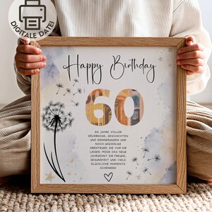 May include: A square wooden frame containing a print with the text Happy Birthday and the number 60, which is filled with a banknote pattern. The design features a black dandelion illustration, small stars, and German text about a 60th birthday.