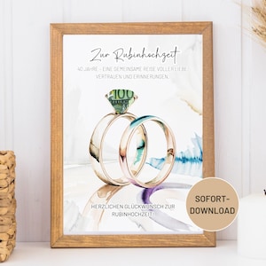Könnte beinhalten: Ein gerahmter Druck mit einem Aquarelldesign, das zwei Eheringe zeigt, einer davon mit einem 100-Euro-Schein als Edelstein. Der Text lautet "Zur Rubinhochzeit" und "40 Jahre - Eine gemeinsame Reise voller Liebe, Vertrauen und Erinnerungen." Ein Button sagt "SOFORT-DOWNLOAD".
