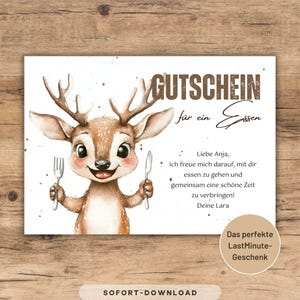 May include: A white gift certificate with a watercolor illustration of a deer holding a fork and knife. The text "GUTSCHEIN für ein Essen" is at the top, with a personal message below. The bottom right corner has a sticker that says "Das perfekte LastMinute-Geschenk".