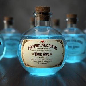 May include: A white ceramic mug with a black handle and the text "But First, Coffee" in a black, bold font. The mug is on a white surface.