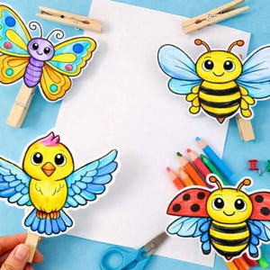 May include: A collection of colorful, cartoon-style paper cutouts of a butterfly, bee, bird, and ladybug, each attached to a wooden clothespin. The background is light blue with a white sheet of paper, colored pencils, scissors, and push pins.