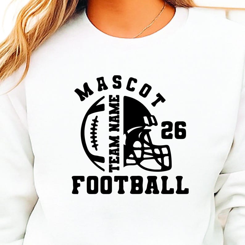 May include: White sweatshirt with a black football-themed graphic. The design includes a football, helmet, the word "MASCOT", "TEAM NAME", the number "26", and the word "FOOTBALL". The sweatshirt is a casual garment.
